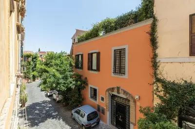 an orange building with a car parked in a street at iFlat Modern & Relaxing apartment in Trastevere in Rome
