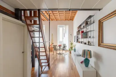 a staircase in a living room with a table at iFlat Modern & Relaxing apartment in Trastevere in Rome