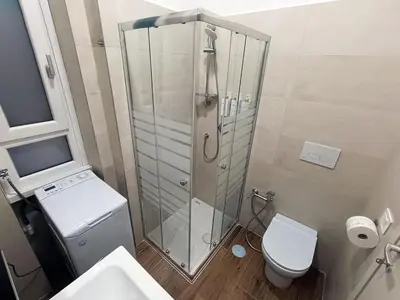 a bathroom with a shower with a toilet and a sink at Locazioni Ostiense - Joy House in Rome