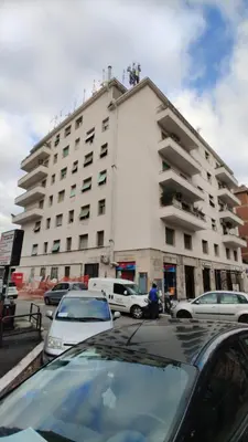 a parking lot with cars parked in front of a building at Locazioni Ostiense - Joy House in Rome