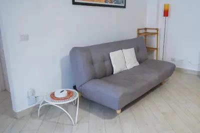 a gray couch sitting in a living room with a table at San Paolo GreenHouse in Rome