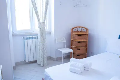 a bedroom with two beds and a chair and a window at San Paolo GreenHouse in Rome