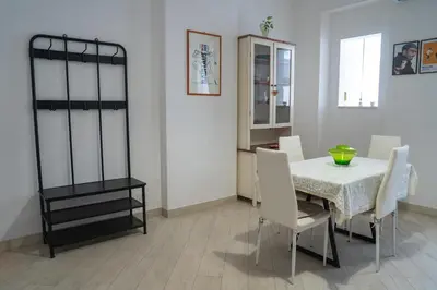 a dining room with a table and white chairs at San Paolo GreenHouse in Rome