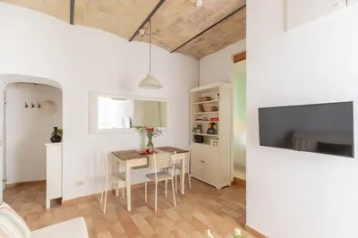 a kitchen and dining room with a table and a tv at iFlat Quiet & cozy apt a few steps from Vatican in Rome