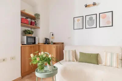 a living room with a white couch and a table with flowers at iFlat Quiet & cozy apt a few steps from Vatican in Rome