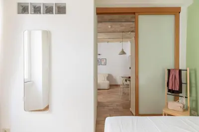 a bedroom with a white bed and a mirror at iFlat Quiet & cozy apt a few steps from Vatican in Rome
