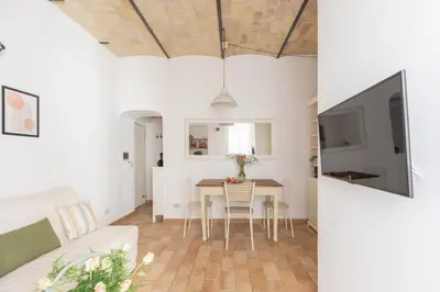 a living room and dining room with a table and a tv at iFlat Quiet & cozy apt a few steps from Vatican in Rome