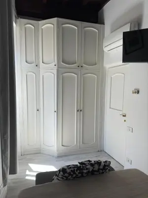 a bedroom with white cabinets and a bed in a room at Pietro's Central Apartament in Rome