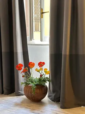 a vase with red and yellow flowers in a window at Pietro's Central Apartament in Rome