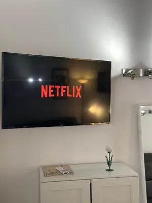a television on a wall with the netflix sign on it at Pietro's Central Apartament in Rome