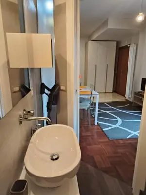 a bathroom with a toilet and a room with a table at Roma Eur - OrangeVibes Loft in Rome