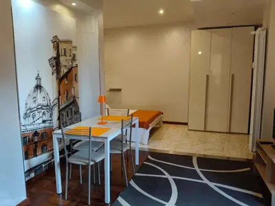 a room with a table and chairs and a bedroom at Roma Eur - OrangeVibes Loft in Rome