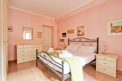 a bedroom with a white bed and a tv at Suite Porta Portese in Rome