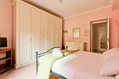a bedroom with a large bed with pink walls at Suite Porta Portese in Rome
