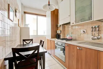 a kitchen with wooden cabinets and a table and chairs at Suite Porta Portese in Rome