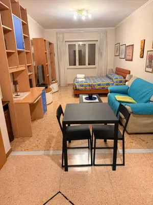 a dining room and living room with a table and chairs at Suite Porta Portese in Rome