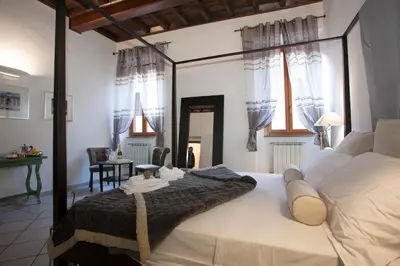 a bedroom with a large bed and a dining room at Magenta Luxury Purificazione in Rome