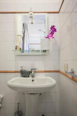 a bathroom with a white sink and a mirror at Magenta Luxury Purificazione in Rome