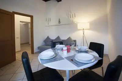 a white dining room table with black chairs and a white table and chairsktop at Magenta Luxury Purificazione in Rome