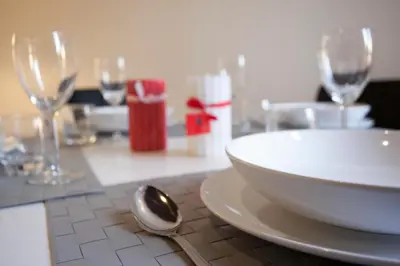 a table with a white plate and wine glasses at Magenta Luxury Purificazione in Rome