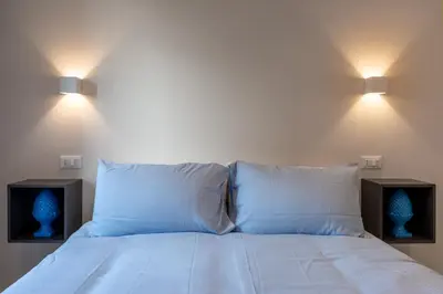 a bedroom with a bed with two lamps on it at CASA VACANZA San LO' ZONA SAN LORENZO TERMINI ROMA in Rome