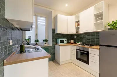 a kitchen with white cabinets and a sink at CASA VACANZA San LO' ZONA SAN LORENZO TERMINI ROMA in Rome