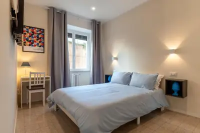 a bedroom with a bed and a table and a window at CASA VACANZA San LO' ZONA SAN LORENZO TERMINI ROMA in Rome