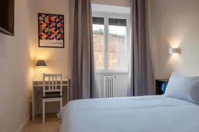 a bedroom with a bed and a desk and a window at CASA VACANZA San LO' ZONA SAN LORENZO TERMINI ROMA in Rome