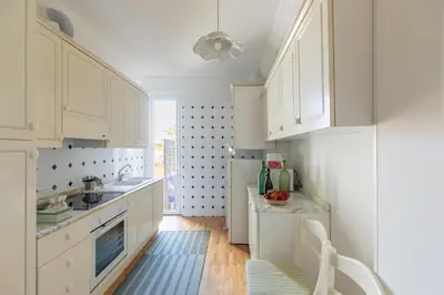 a kitchen with white cabinets and a refrigerator at iFlat Pantheon Peaceful & Comfortable Apartment in Rome