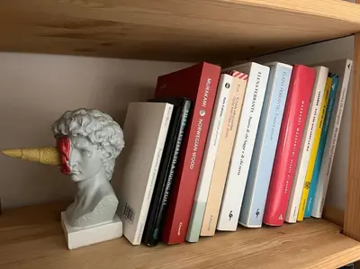 a shelf with books and a bust of a head at Casa Vivi in Rome