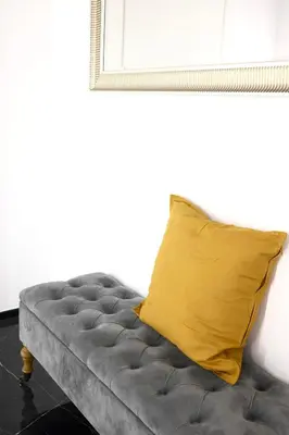 a gray couch with a yellow pillow on it at Turati Inn in Rome