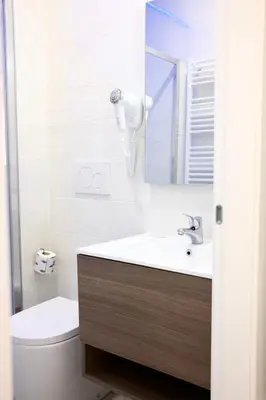 a bathroom with a sink and a toilet and a mirror at Turati Inn in Rome