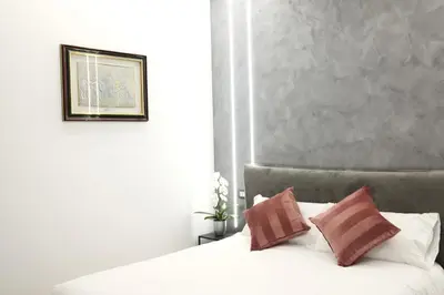 a bedroom with a white bed with brown pillows at Turati Inn in Rome