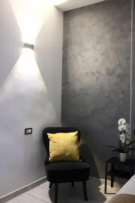 a black chair with a yellow pillow in a room at Turati Inn in Rome