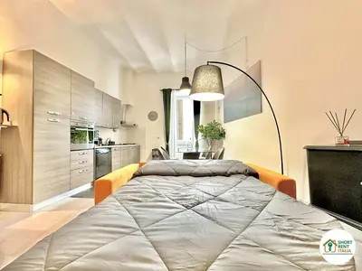 a bedroom with a large bed and a kitchen at Corso Francia - Exclusive House in Rome