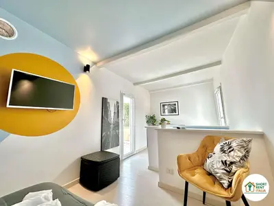 a living room with a chair and a tv on the wall at Corso Francia - Exclusive House in Rome