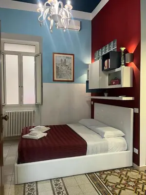 a bedroom with a bed with a red wall at Nicky's House in Rome