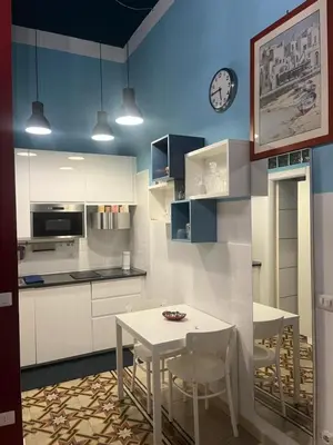 a kitchen with a table and a clock on the wall at Nicky's House in Rome