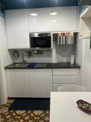 a white kitchen with a sink and a microwave at Nicky's House in Rome