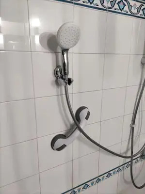 a shower with a shower head on a tiled wall at Colosseo Vintage Apartment in Rome