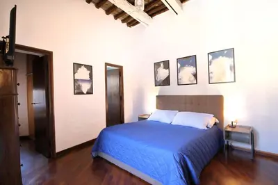 a bedroom with a bed with blue sheets and pictures on the wall at Pantheon Terrace 2 BR Apartment in Rome