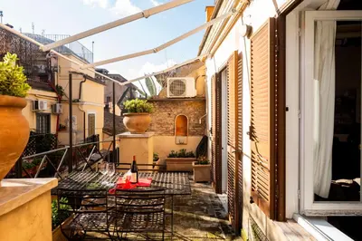 an outdoor patio with tables and chairs on a balcony at Pantheon Terrace 2 BR Apartment in Rome