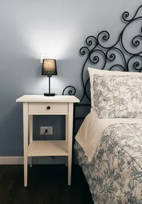 a bedside table with a lamp next to a bed at Your Place in Trastevere in Rome