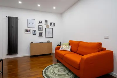 an orange couch in a living room with a rug at Your Place in Trastevere in Rome