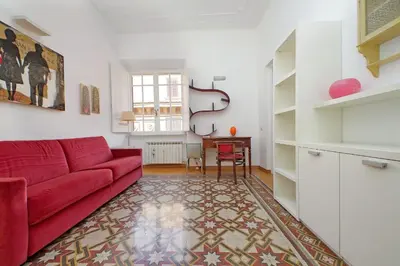 a living room with a red couch and a table at Parioli, Bright And Quiet 2BR Apartment By Halldis in Rome