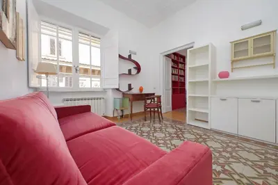 a living room with a red couch and a table at Parioli, Bright And Quiet 2BR Apartment By Halldis in Rome