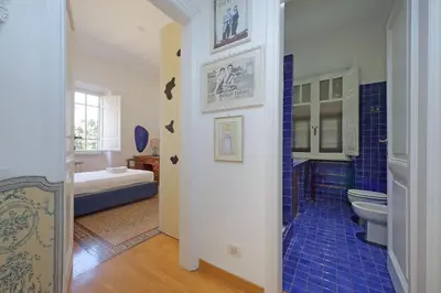 a bathroom with a toilet and a blue tile floor at Parioli, Bright And Quiet 2BR Apartment By Halldis in Rome