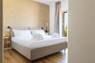 a bedroom with a large white bed with white pillows at Elysium Suites Colosseo in Rome