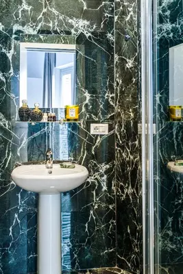 a bathroom with a sink and a mirror at Elysium Suites Colosseo in Rome