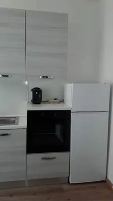a white kitchen with a stove and a refrigerator at ISABEL Apartment in Rome